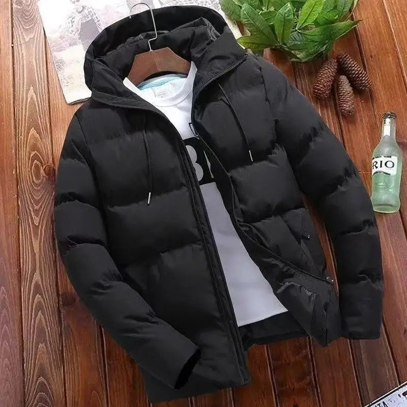 Black puffer jacket on a hanger against a wooden background with a bottle and leaves.